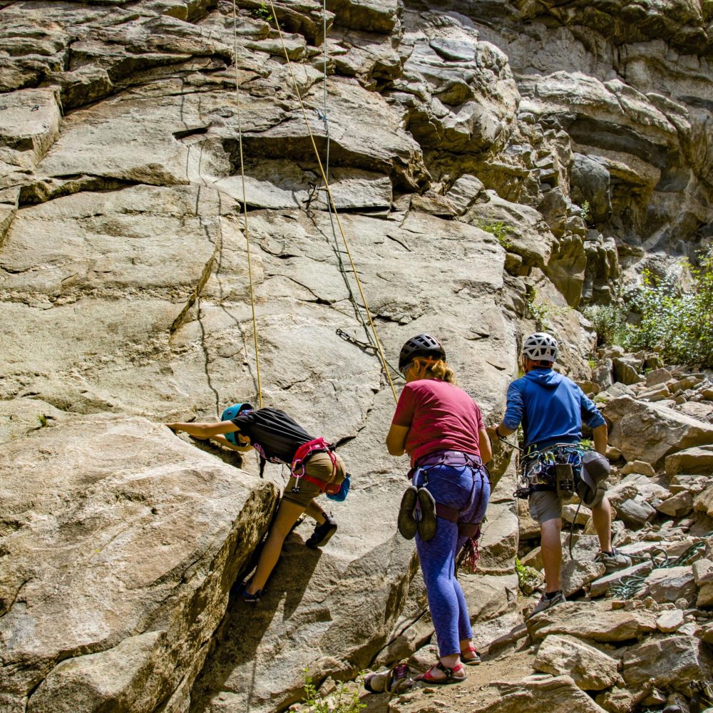 New climber belaying another novice during an introductory rock climbing lesson.